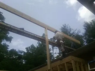 Carpenter setting a ridge beam over a new addition frame — Ice Dam Removal by Roofing Brothers in Dauphin