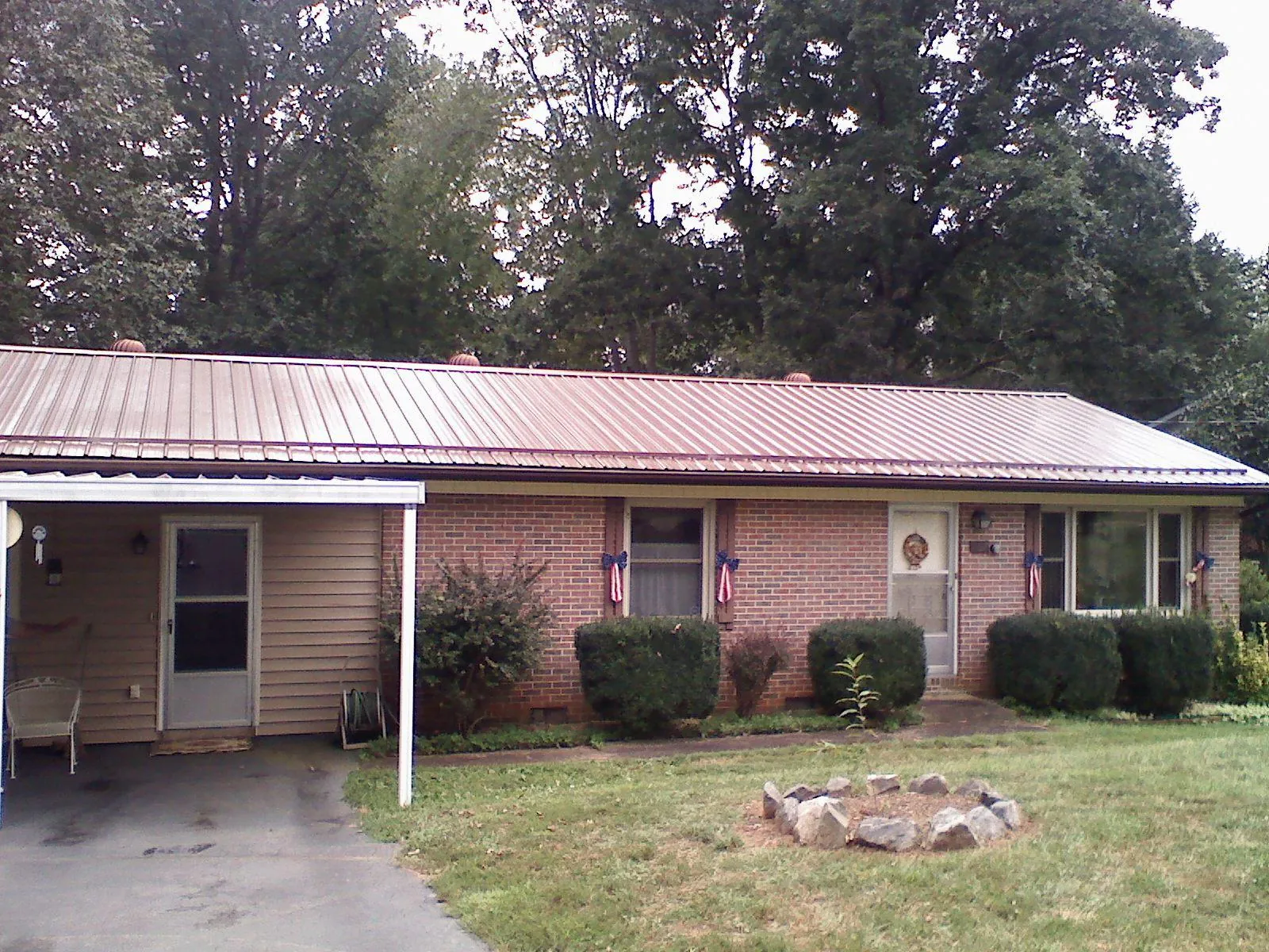 Bronze metal roof and carport on a brick ranch home — Roof Repair work by our crew in Dauphin