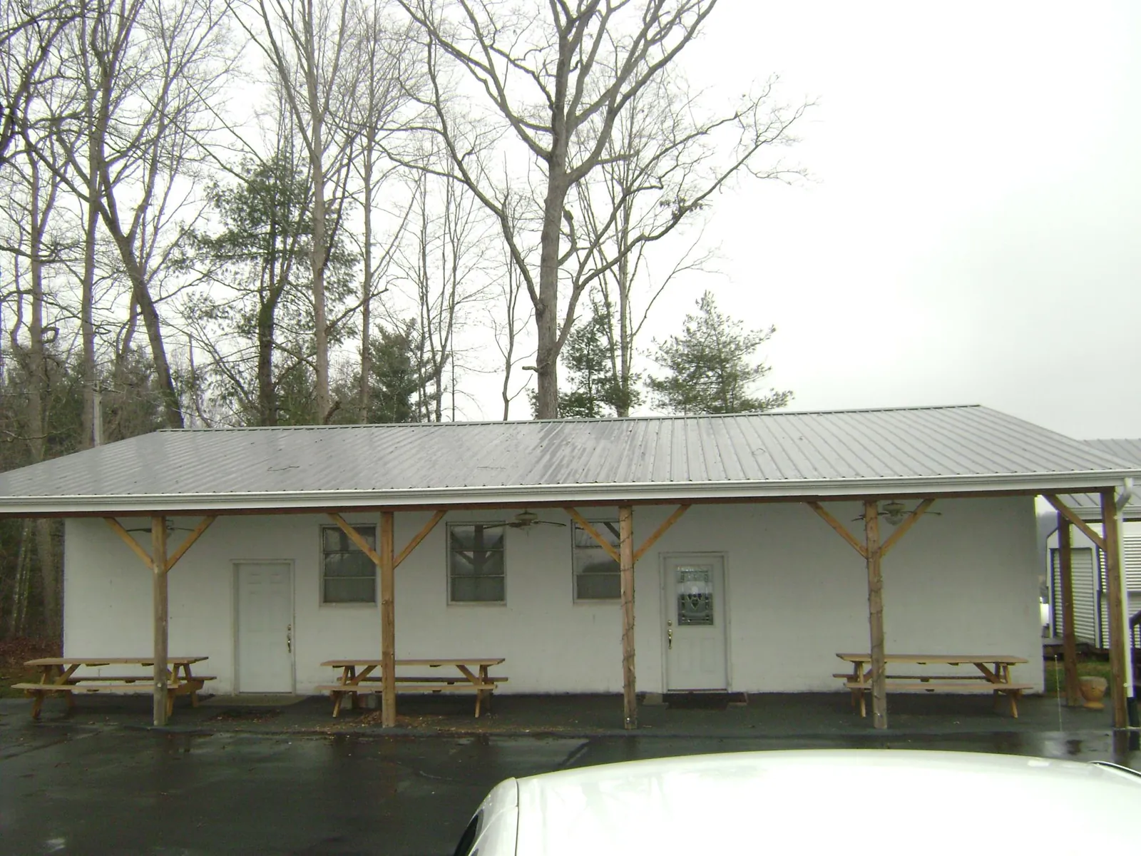 Gray metal roof over a block building with a timber post porch in Dauphin